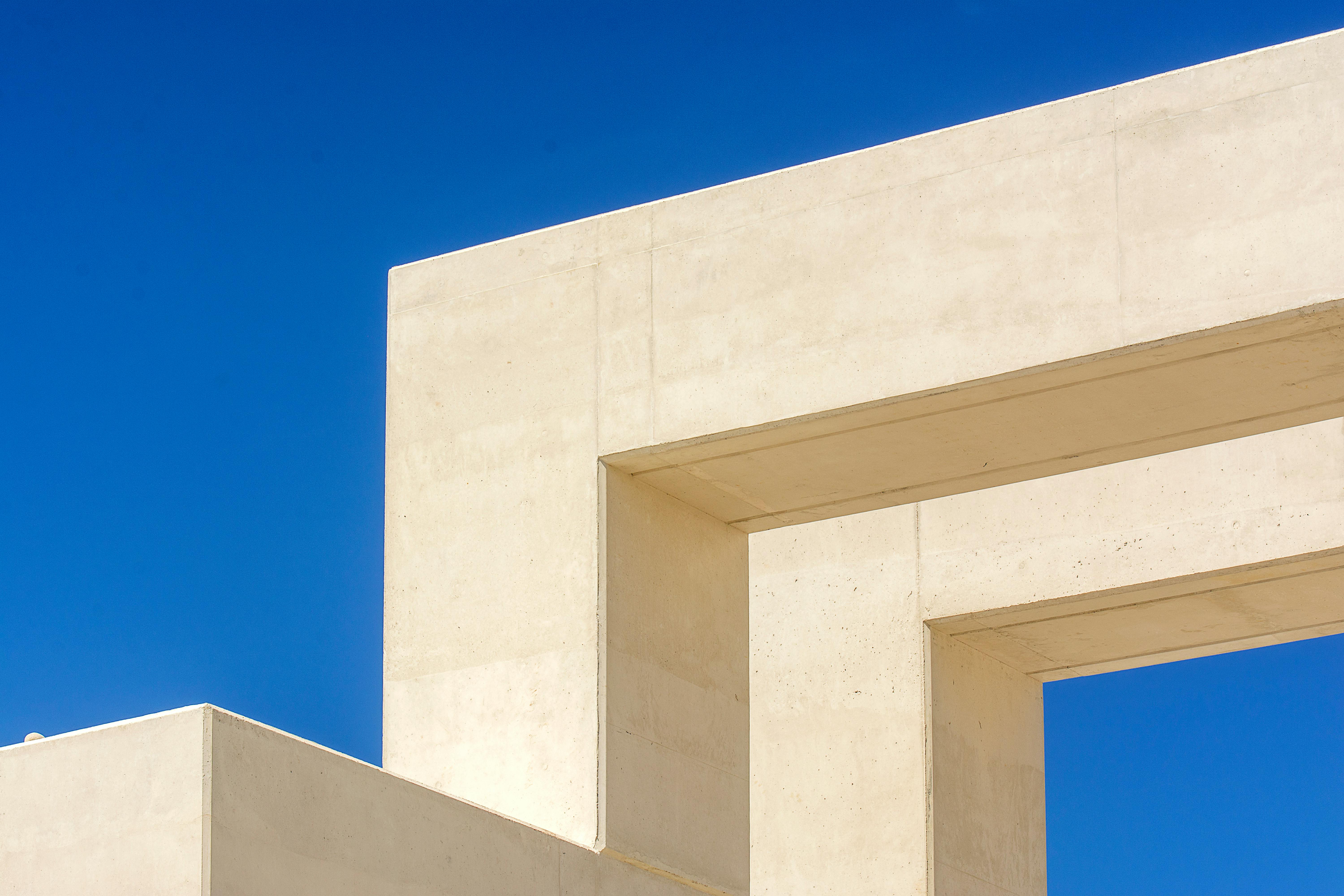 Abstract view of a modern concrete structure in Le Havre with a bright blue sky backdrop.
