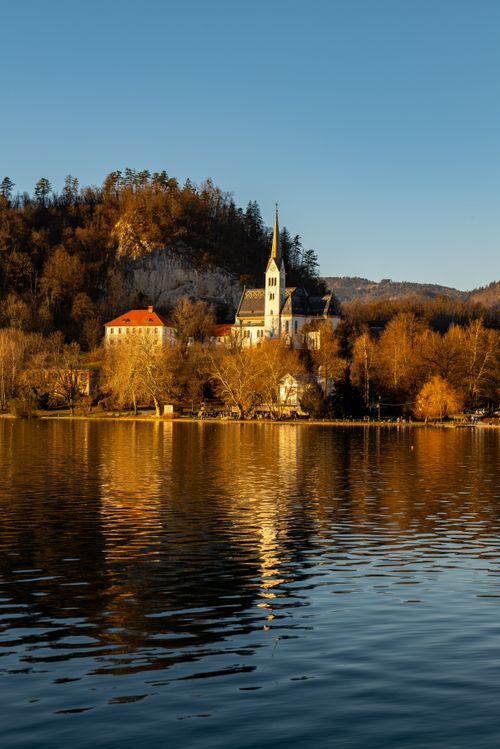 Free Scenic view of St. Martin's Church in Bled, Slovenia with autumn reflections on the lake. Stock Photo