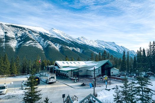 Stunning winter scene at Banff Gondola terminal with snowy mountains in Alberta, Canada.