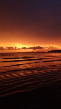 Stunning sunset over the ocean with vivid colors and calm waves creating a serene atmosphere.