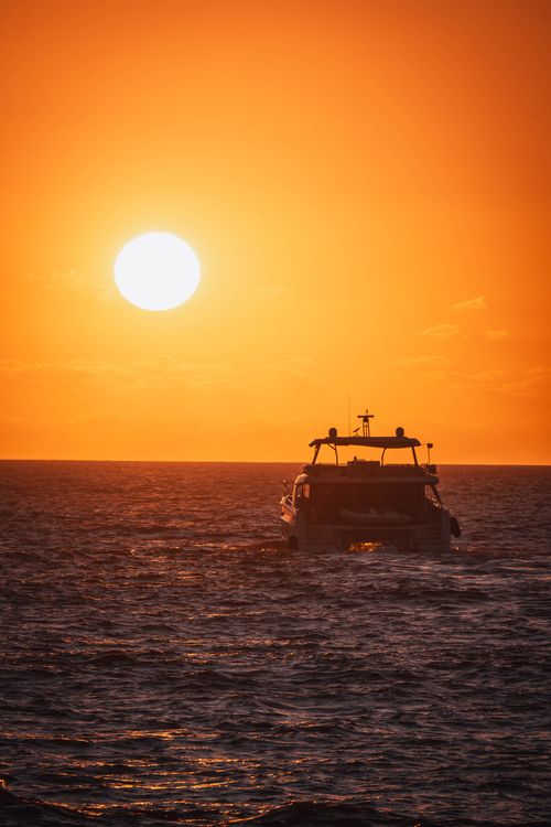 Free Elegant yacht sailing at sunset in Nuevo Vallarta, Mexico. Perfect for travel and leisure imagery. Stock Photo