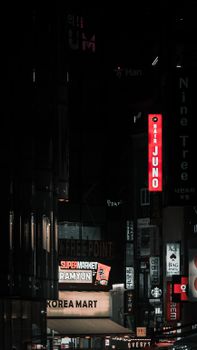Vibrant city street with Korean signs and night lighting in urban setting.