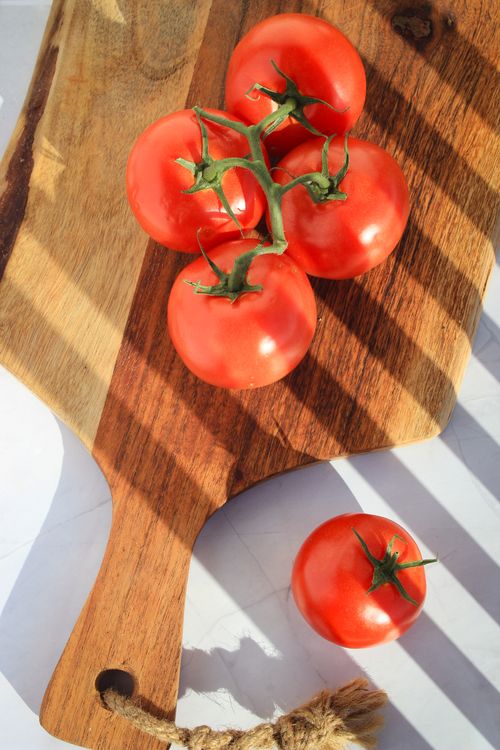 Free Close-up of ripe tomatoes on cutting board with natural light. Stock Photo