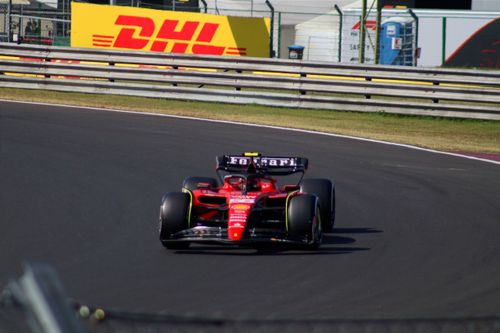 Free Scuderia Ferrari Formula 1 car racing at Mogyoród track, showcasing speed and precision. Stock Photo