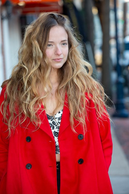 Free Stylish woman in a bold red coat walking in the city, embracing urban fashion. Stock Photo
