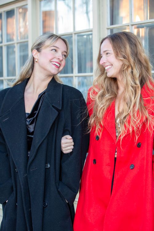 Free Two women smiling and enjoying the winter season in stylish coats outdoors. Stock Photo