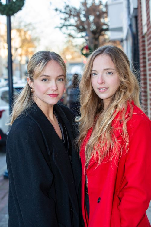 Free Two stylish young women pose confidently on a city street in winter attire. Stock Photo