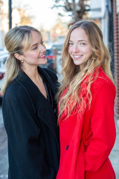 Free Two women smiling in stylish coats outdoors on a sunny winter day. Stock Photo