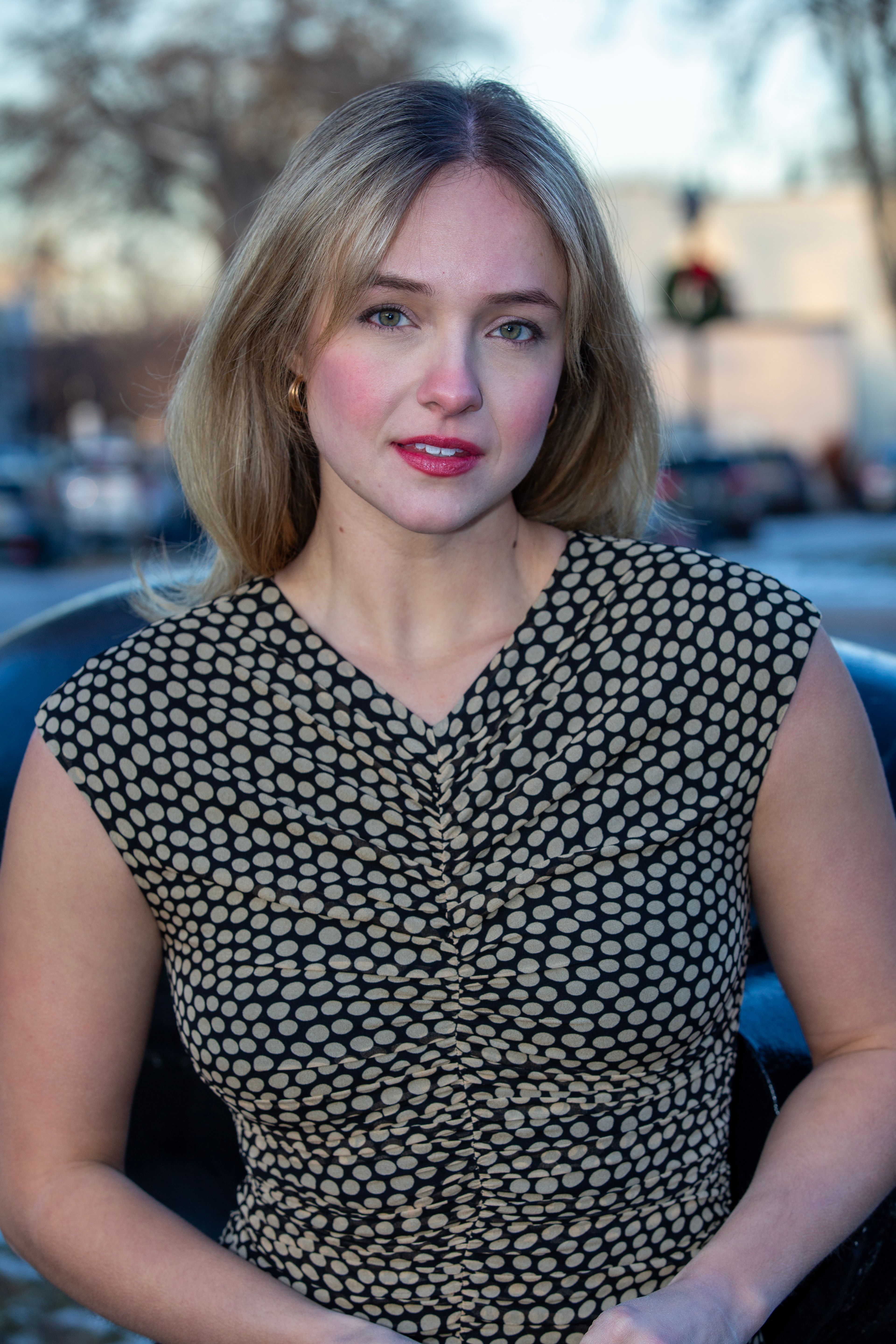 An elegant portrait of a woman in a polka dot dress taken outdoors.