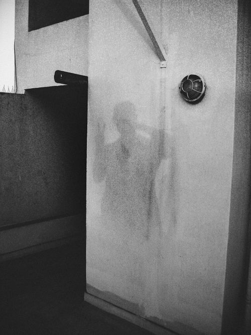 Free Eerie shadow of person on building wall in black and white, high contrast urban setting. Stock Photo