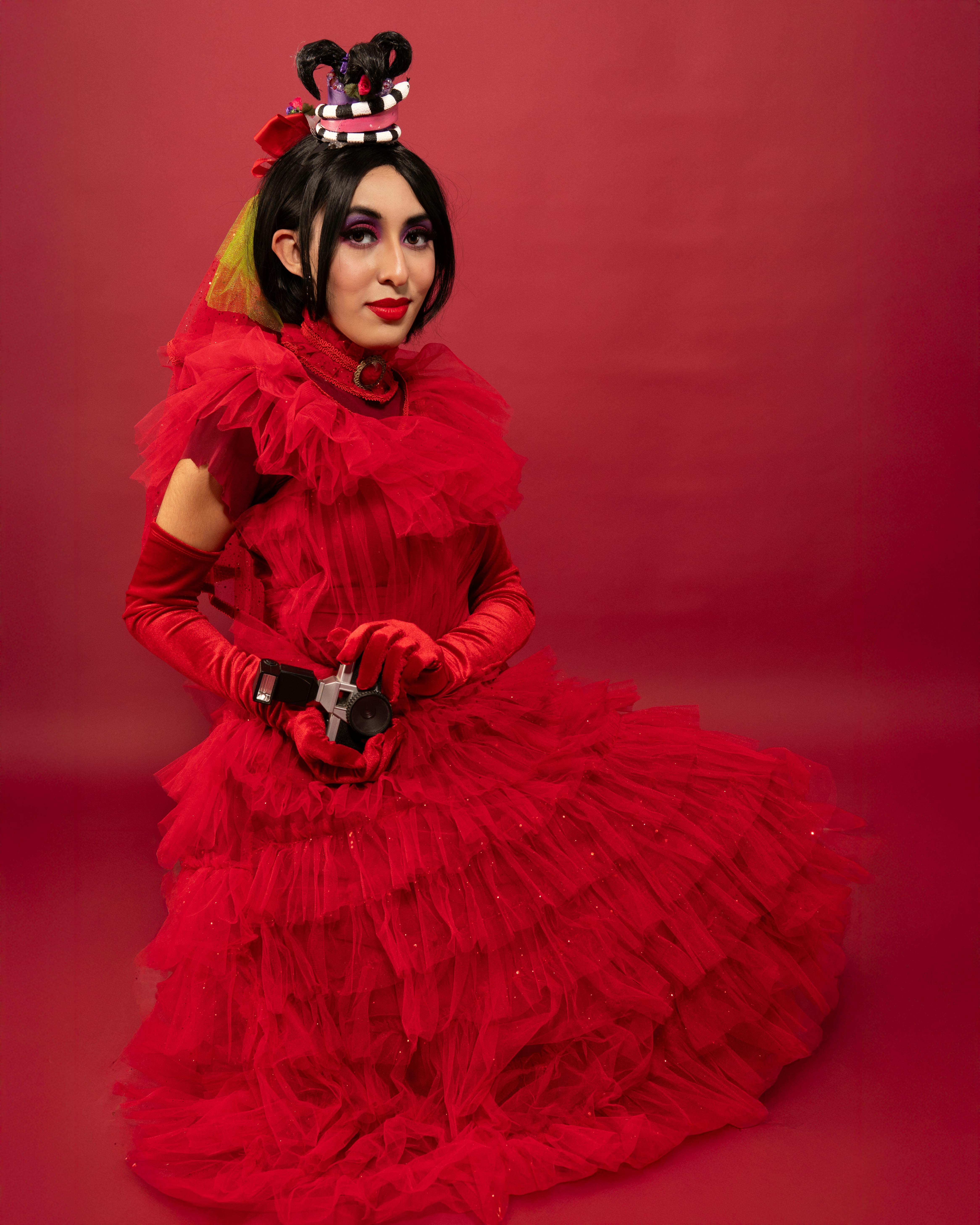 Ücretsiz Lydia Deetz'den esinlenerek hazırlanan, çarpıcı kırmızı kıyafetli ve yaratıcı saç modelli cosplay portresi. Stok Fotoğraflar