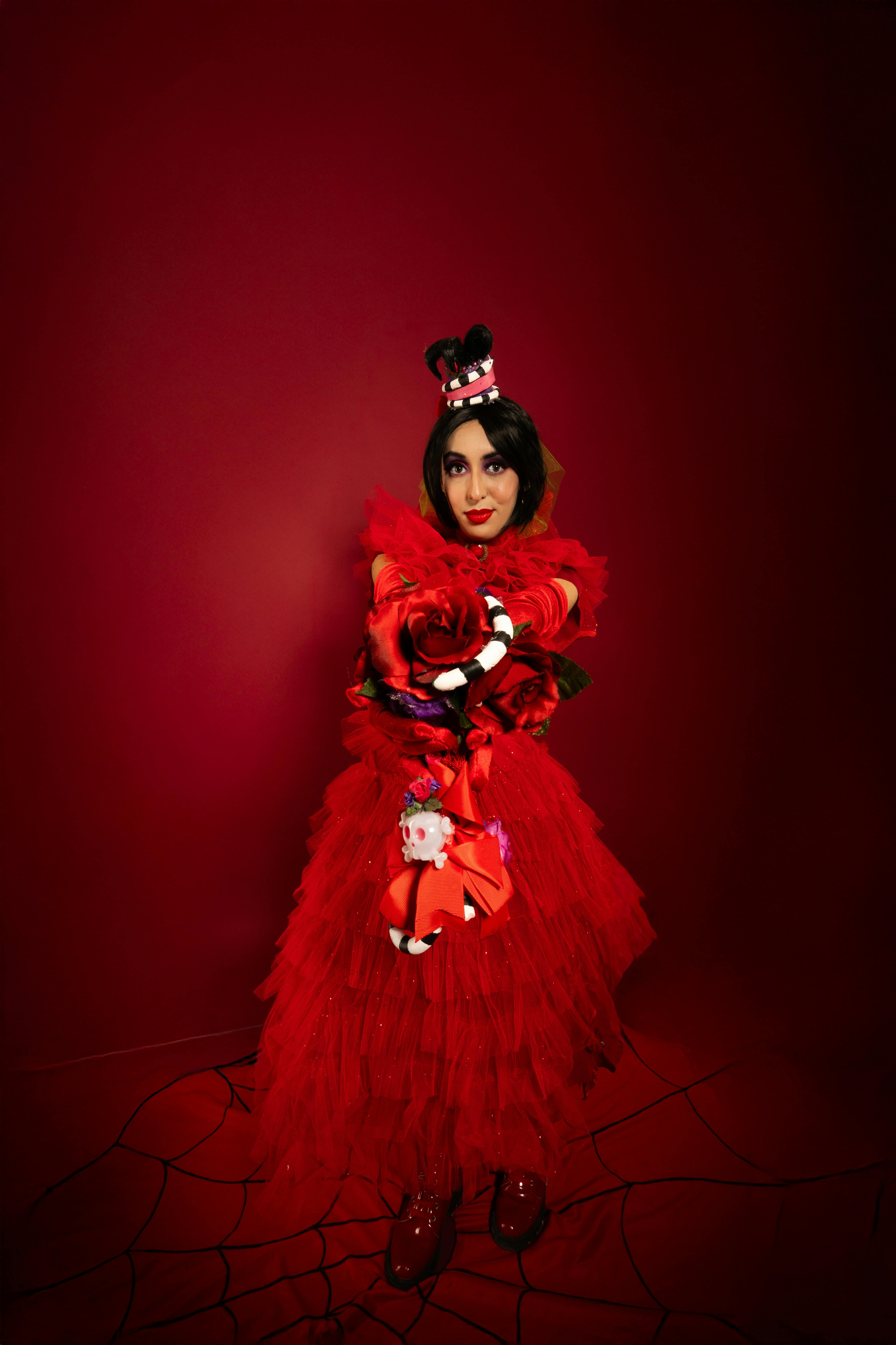 grátis Retrato cosplay criativo em um traje vermelho vibrante contra um fundo combinando. Foto profissional