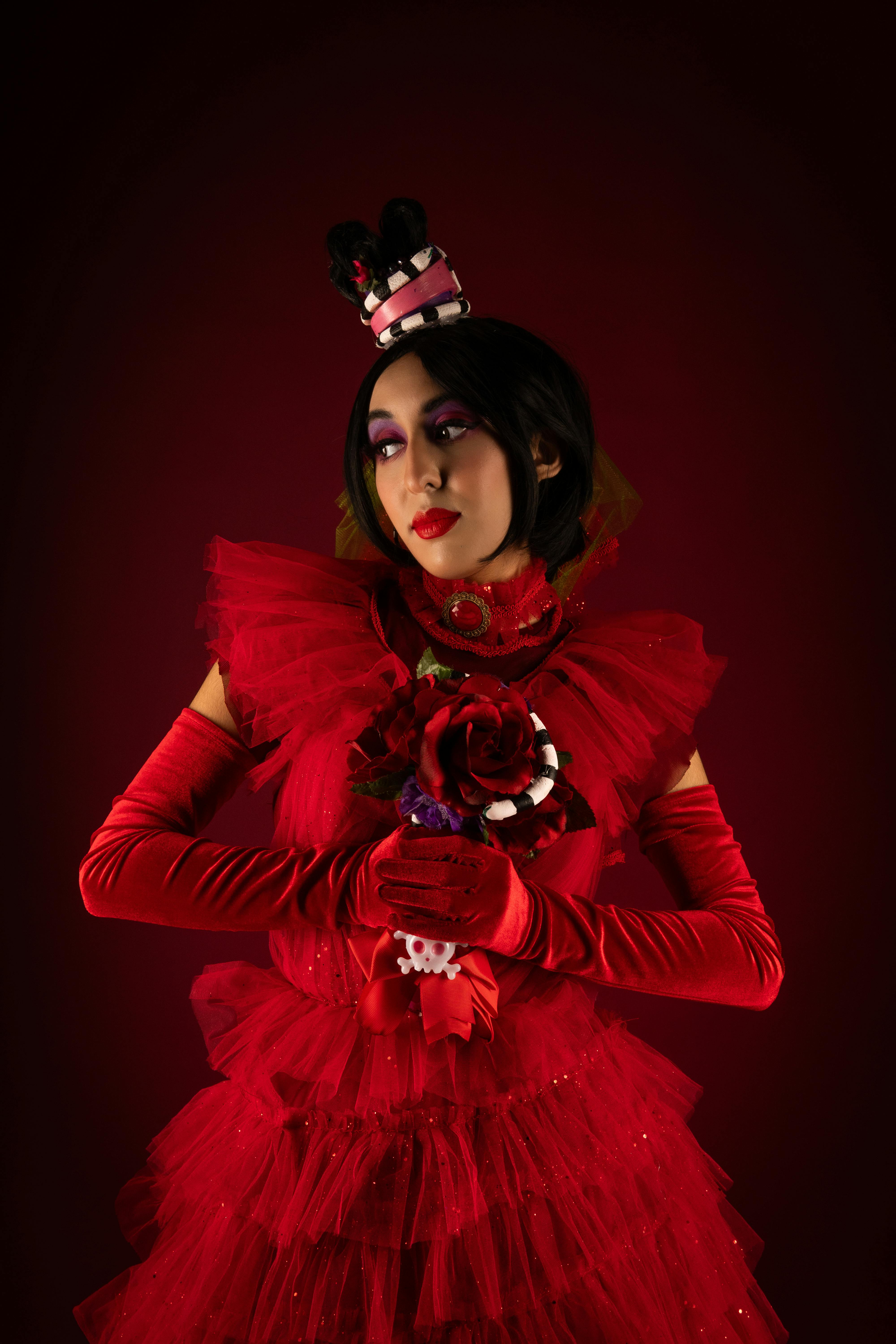 Ücretsiz Kırmızı elbise ve canlı makyajla karanlık bir arka plana karşı bir karakter cosplay'inin çarpıcı portresi. Stok Fotoğraflar