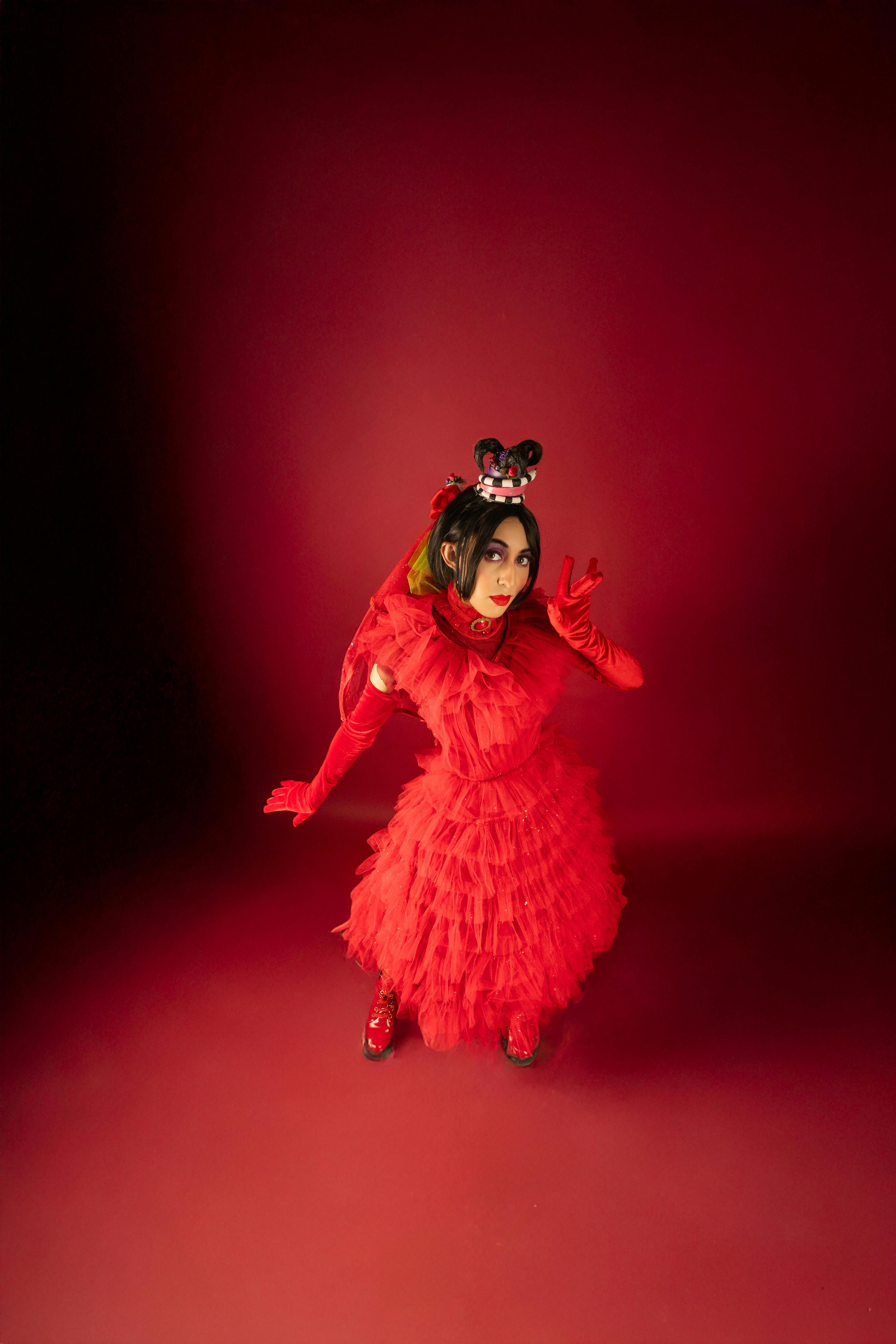 common:alt.prefix Kırmızı cosplay kıyafetli bir kişinin dramatik ışıklandırmayla çarpıcı portresi. common:alt.postfix