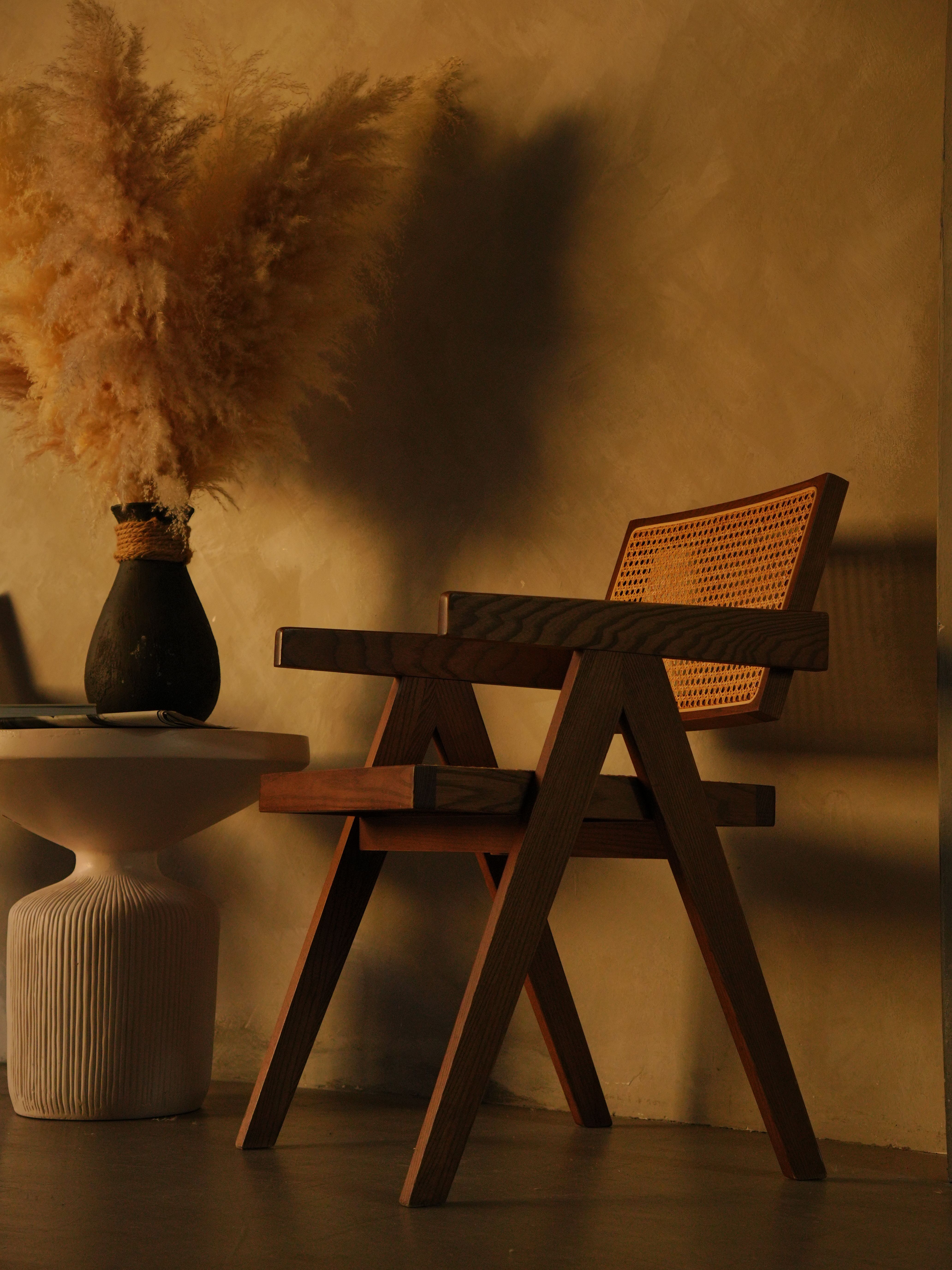 Salon bohème avec fauteuil en rotin et pampas dans un vase en céramique