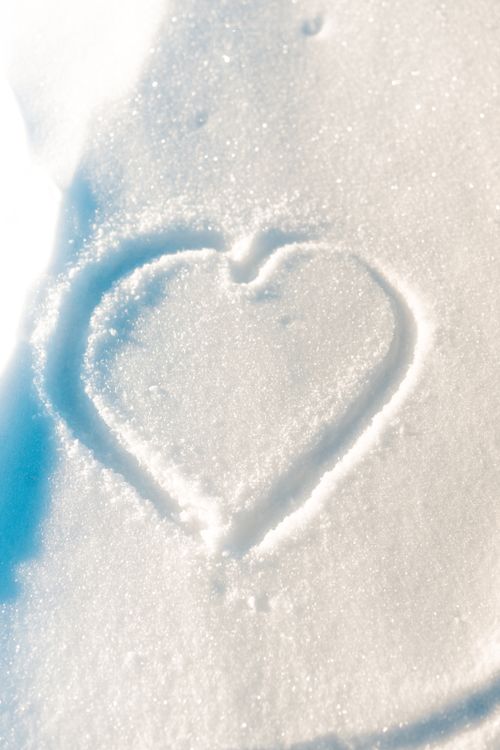 Free A heart shape softly inscribed in pristine white snow, capturing a sense of romance. Stock Photo