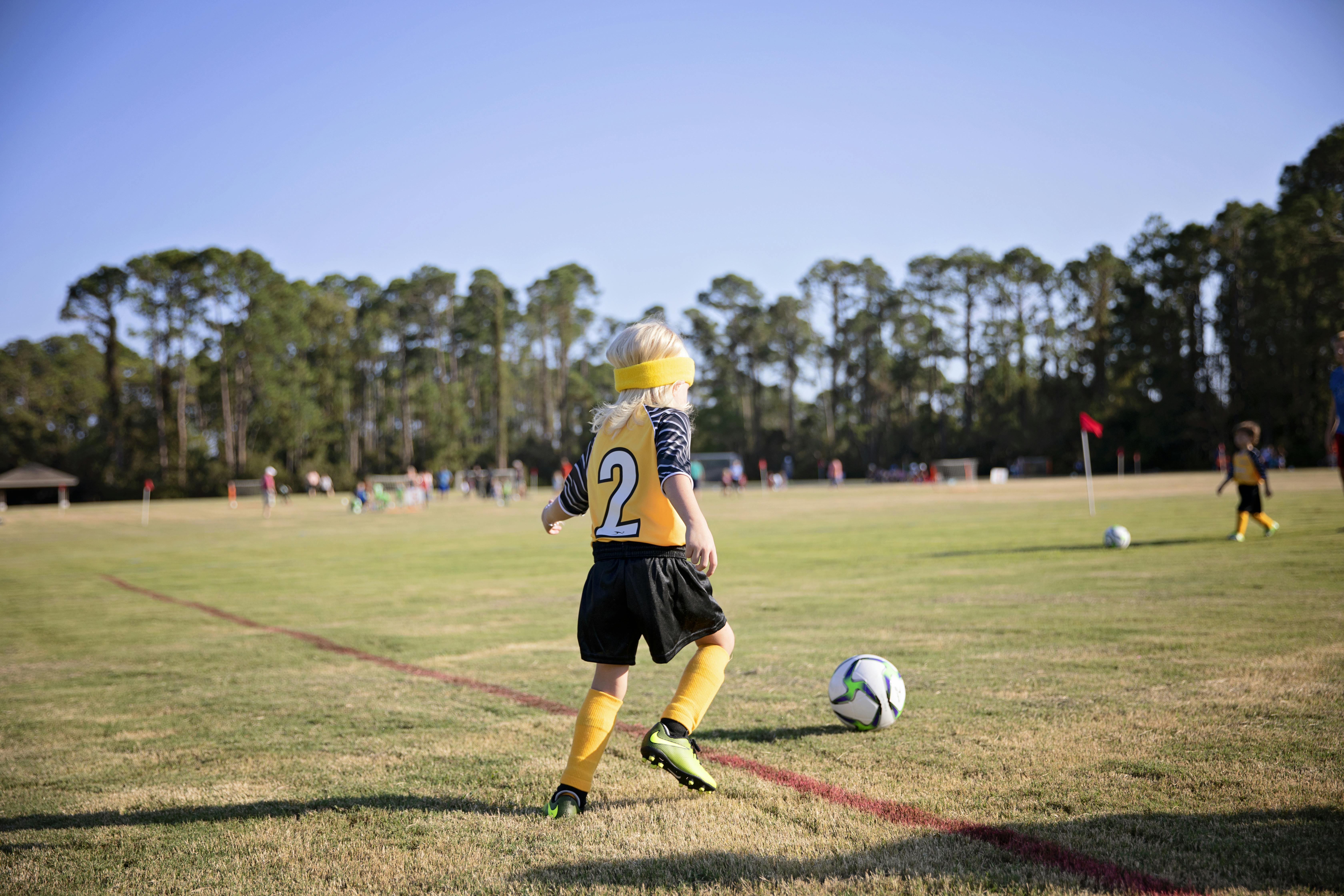 Boy Wearing Yellow and White Jersey Playing Soccer Field ...