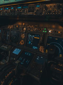 Close-up of an airplane cockpit featuring illuminated control panels and flight instruments.