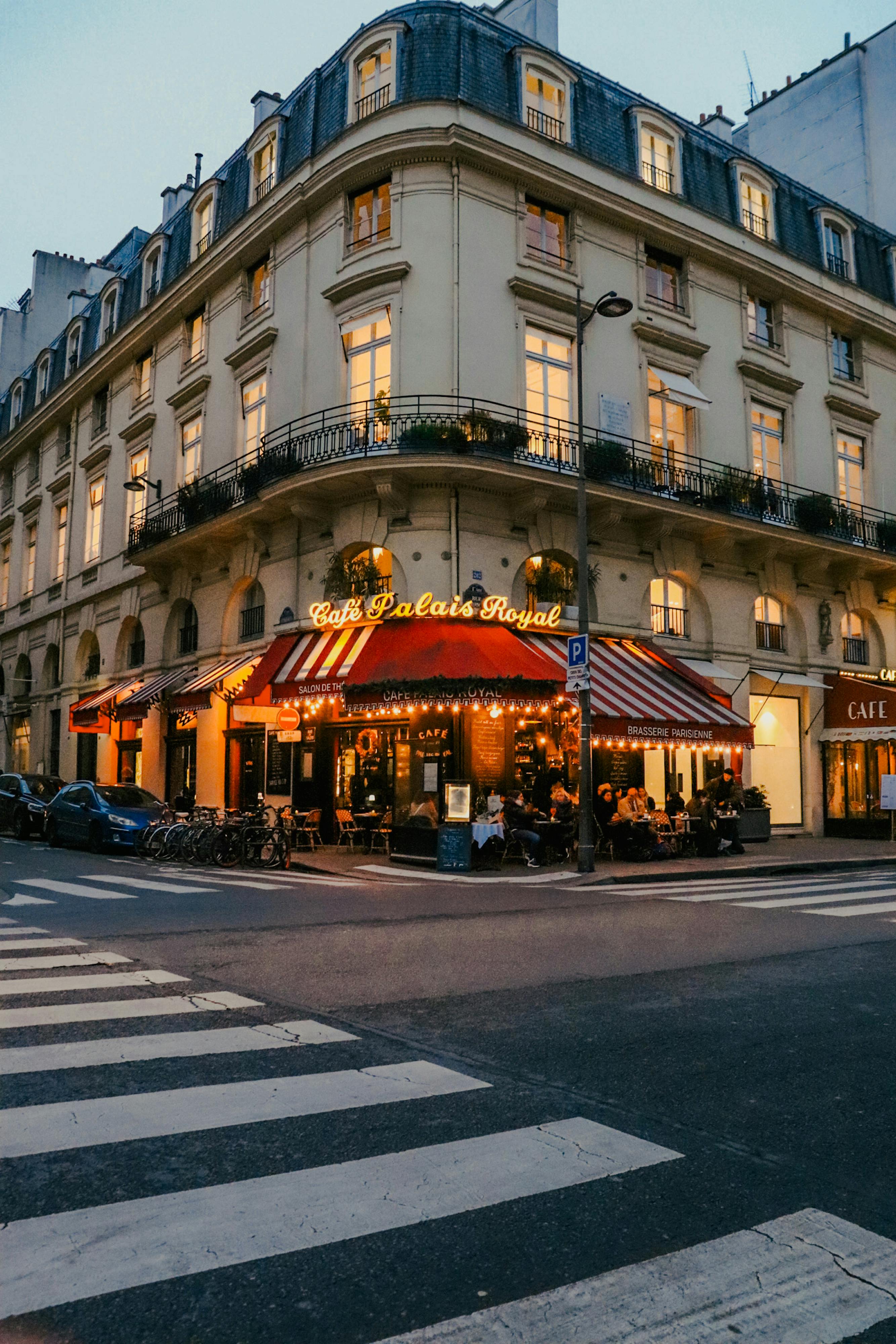Free A cozy Parisian cafe facade at dusk in the heart of the city, capturing vibrant evening life. Stock Photo