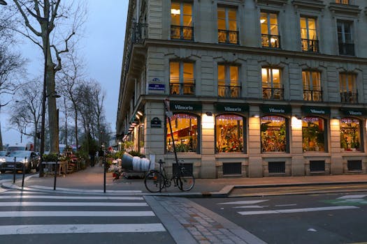 A picturesque evening view of a Paris street corner with charming architecture and warm lights.