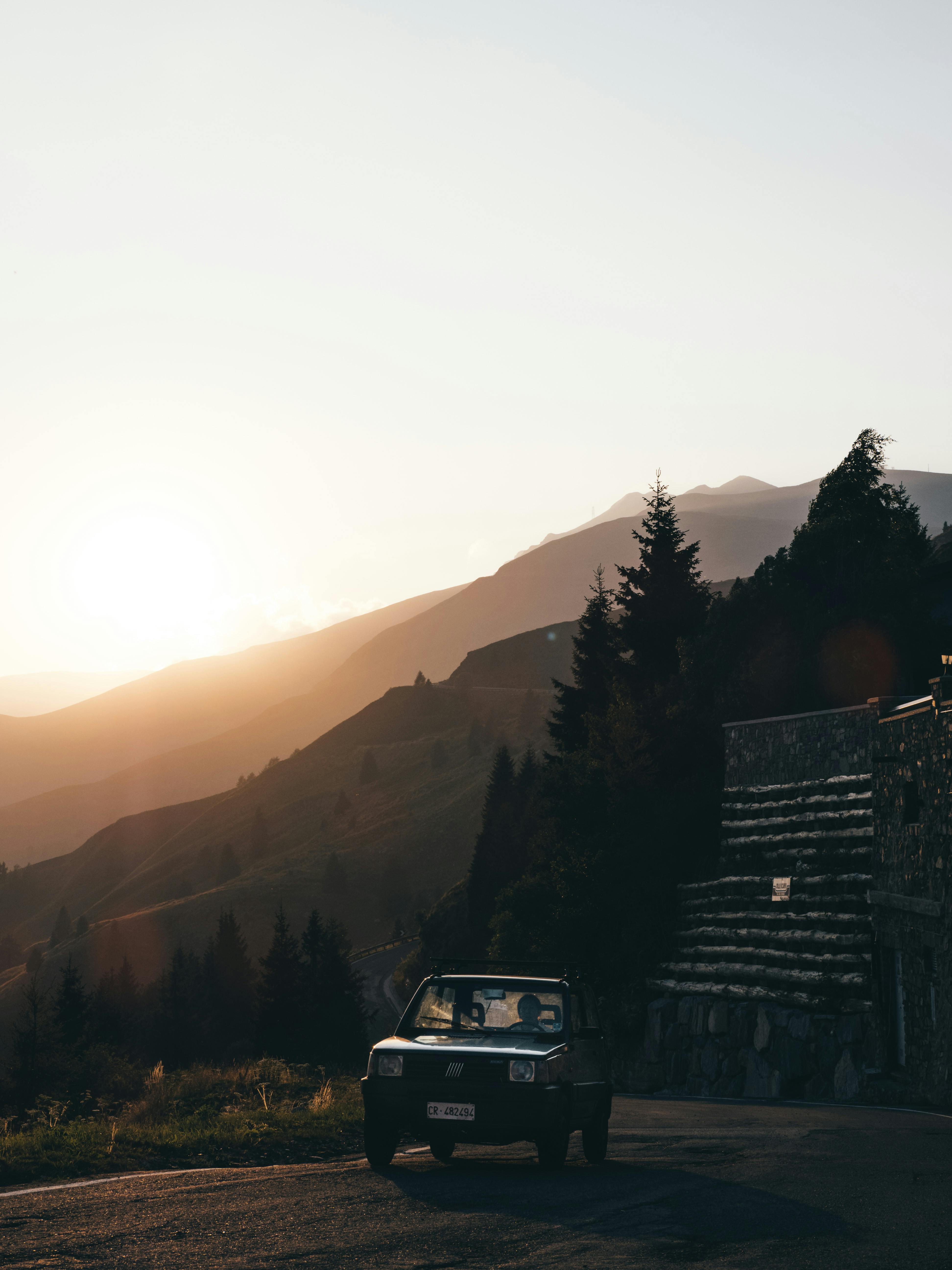 日落时分，一辆老爷车沿着风景优美的山路行驶