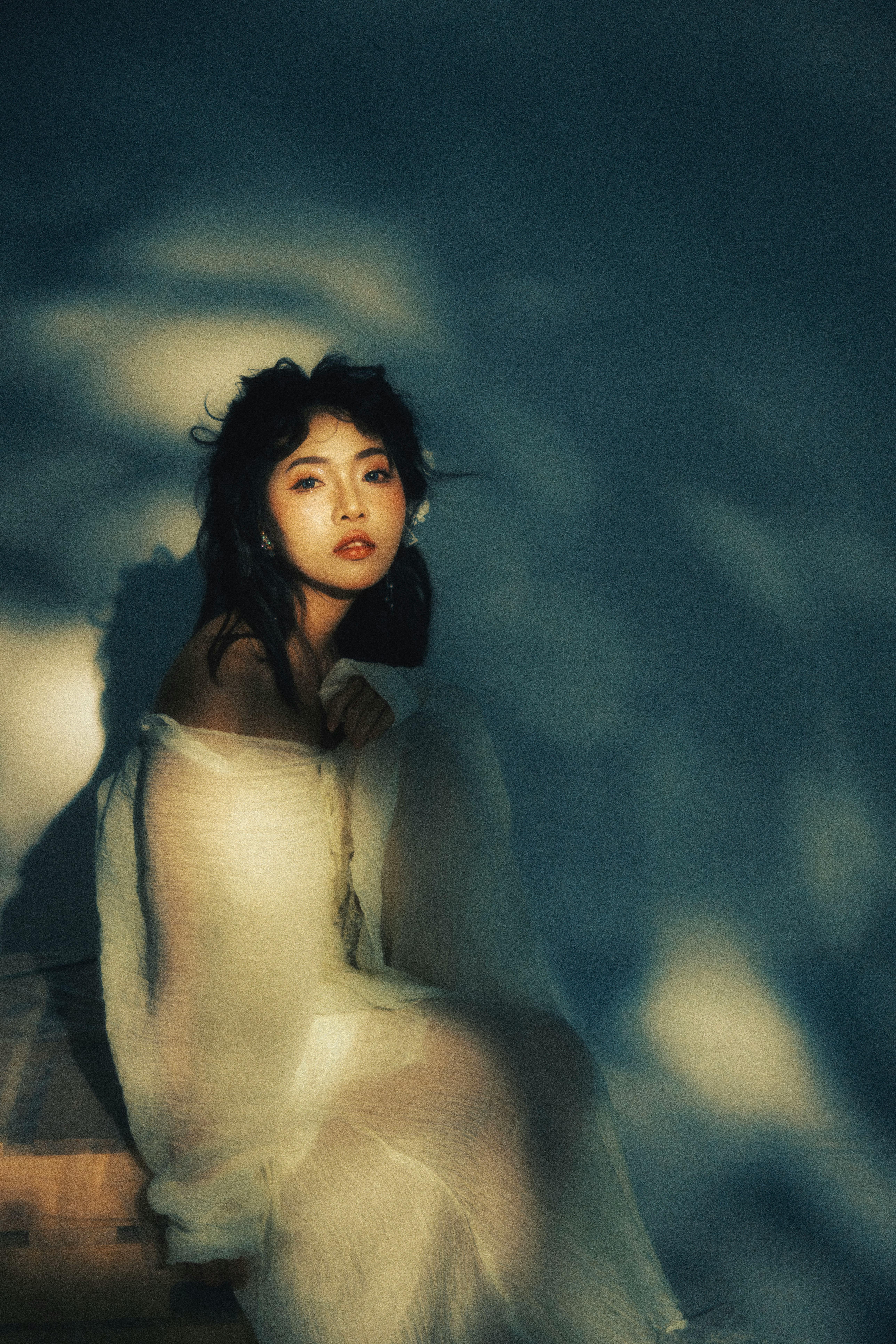 Artistic portrait of a woman bathed in soft shadows creating a moody atmosphere.