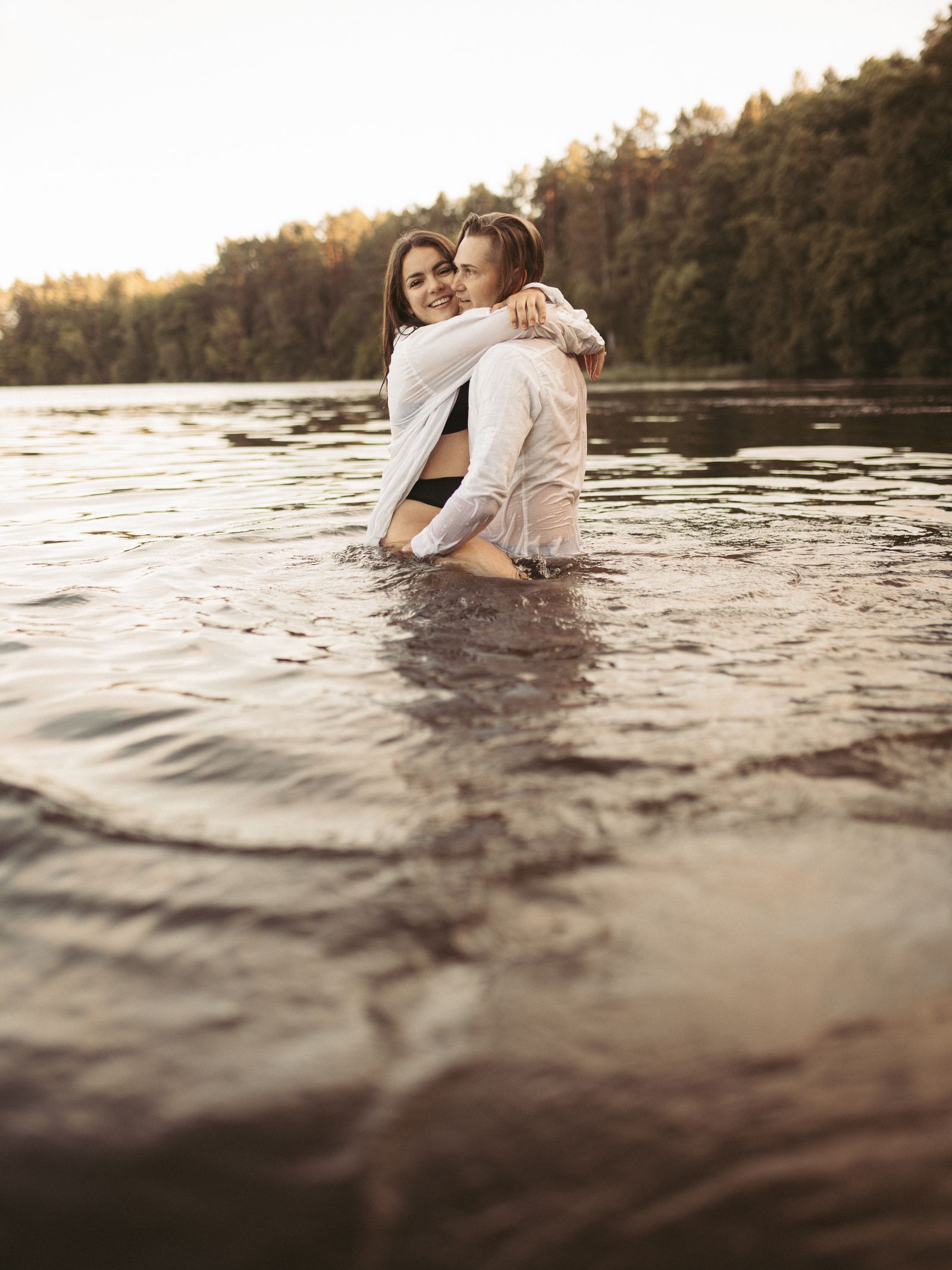 Couple embracing beside a calm lake