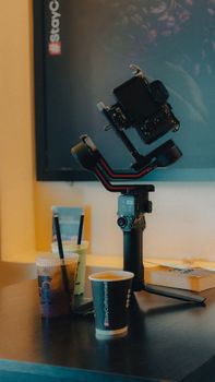 A filmmaking gimbal setup with cold drinks on a table for cinematic shoots.