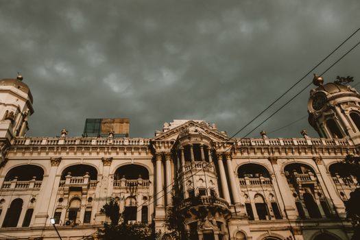 Explore the historic colonial architecture of Kolkata, India under dramatic cloudy skies.