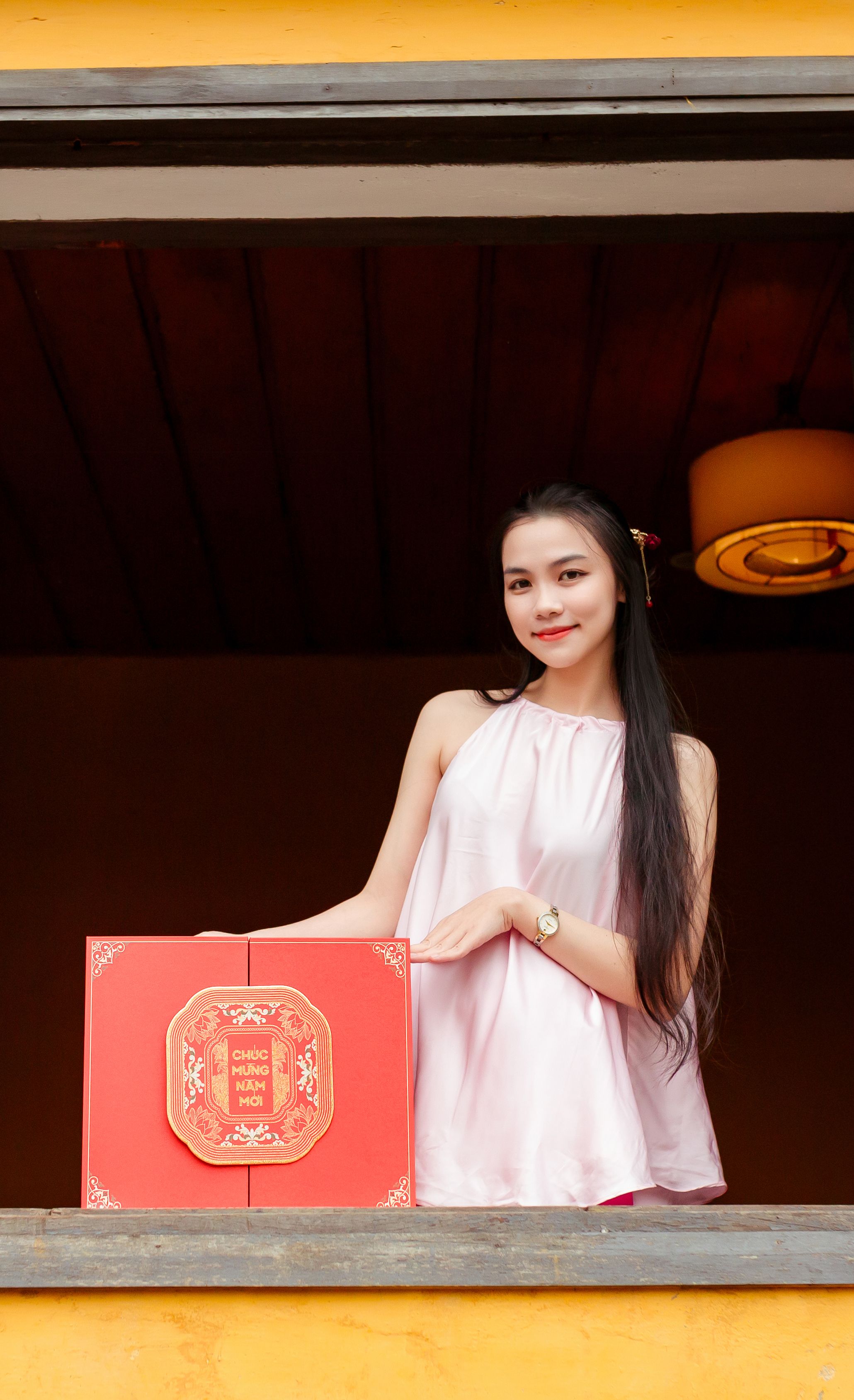 Portrait of a Vietnamese woman holding a traditional gift box in Hội An.