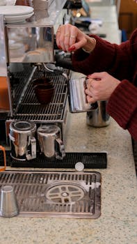 A skilled barista prepares coffee at a café in İstanbul, Türkiye, showcasing espresso brewing technique.