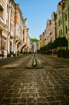 Cobblestone street flanked by colorful historic buildings under a clear blue sky.