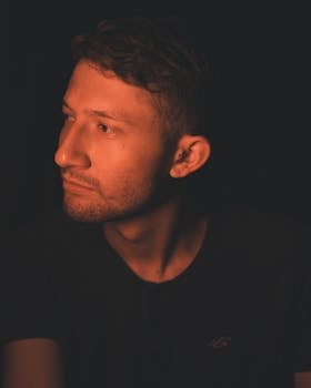 Candid portrait of a man with warm lighting, evoking introspection and emotion.