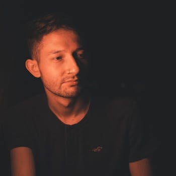 Candid portrait of a man in warm ambient light, creating a moody atmosphere.