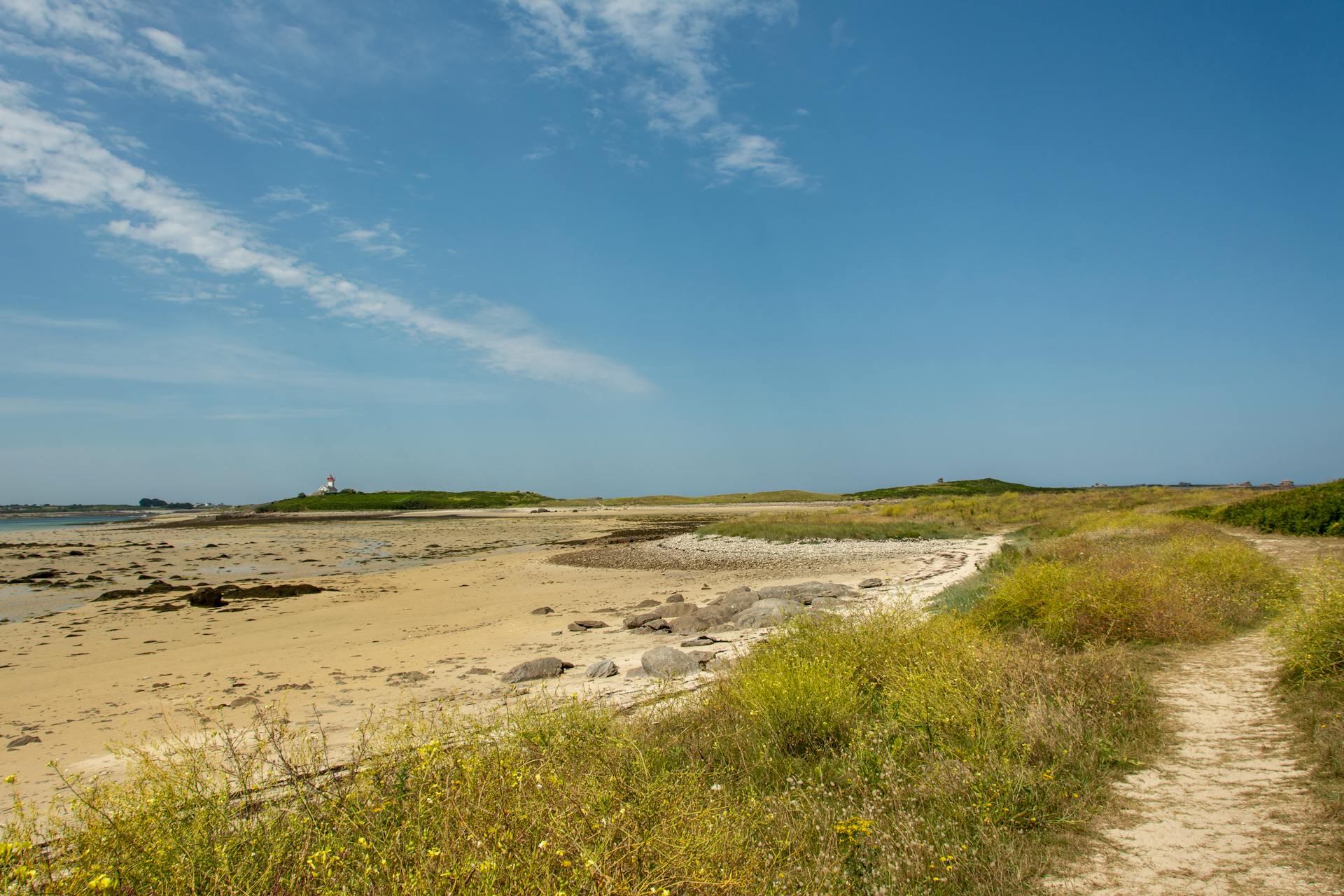 Beautiful sandy beach and hiking trail in Plouguerneau, Bretagne with lighthouse view.