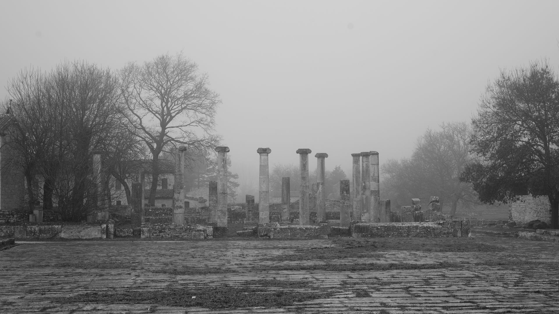 Gri bir gökyüzü altında antik Roma taş duvarlarının ve kalıntılarının geniş açılı görünümü