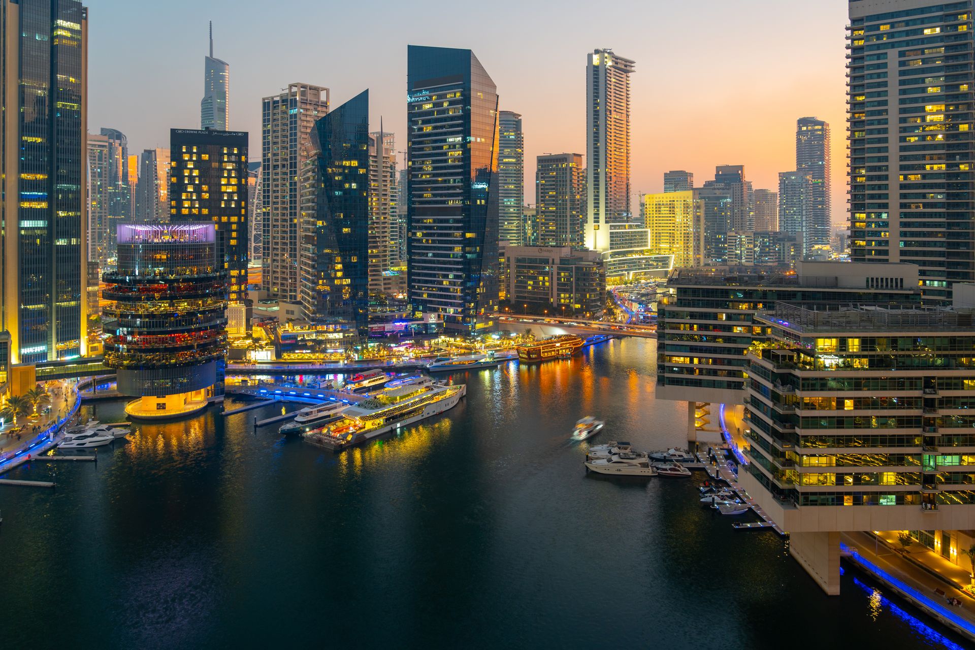 A breathtaking twilight cityscape of Dubai Marina with illuminated skyscrapers and waterways.