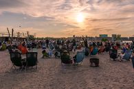 People enjoy a relaxing evening at a sandy beachfront in Copenhagen with a vibrant atmosphere.