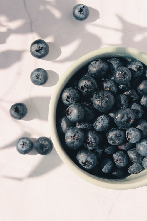 Free Close-up of ripe blueberries in a bowl under soft sunlight, casting gentle shadows. Stock Photo