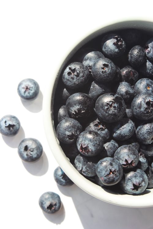 Free A vibrant close-up of fresh blueberries in a white bowl, ideal for healthy food themes. Stock Photo