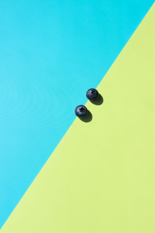 Free Minimalist image of two blueberries on a bright geometric background. Perfect for modern designs. Stock Photo