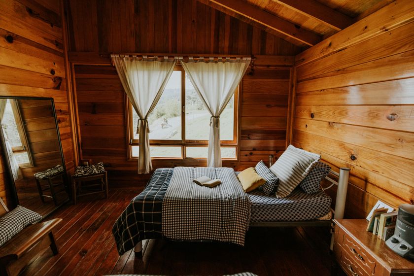 Upper-floor suite at Nāra with pale walls and a low bed under the eaves