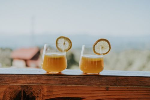 Free Two refreshing citrus drinks with lemon slices on a wooden balcony, ideal for outdoor enjoyment. Stock Photo