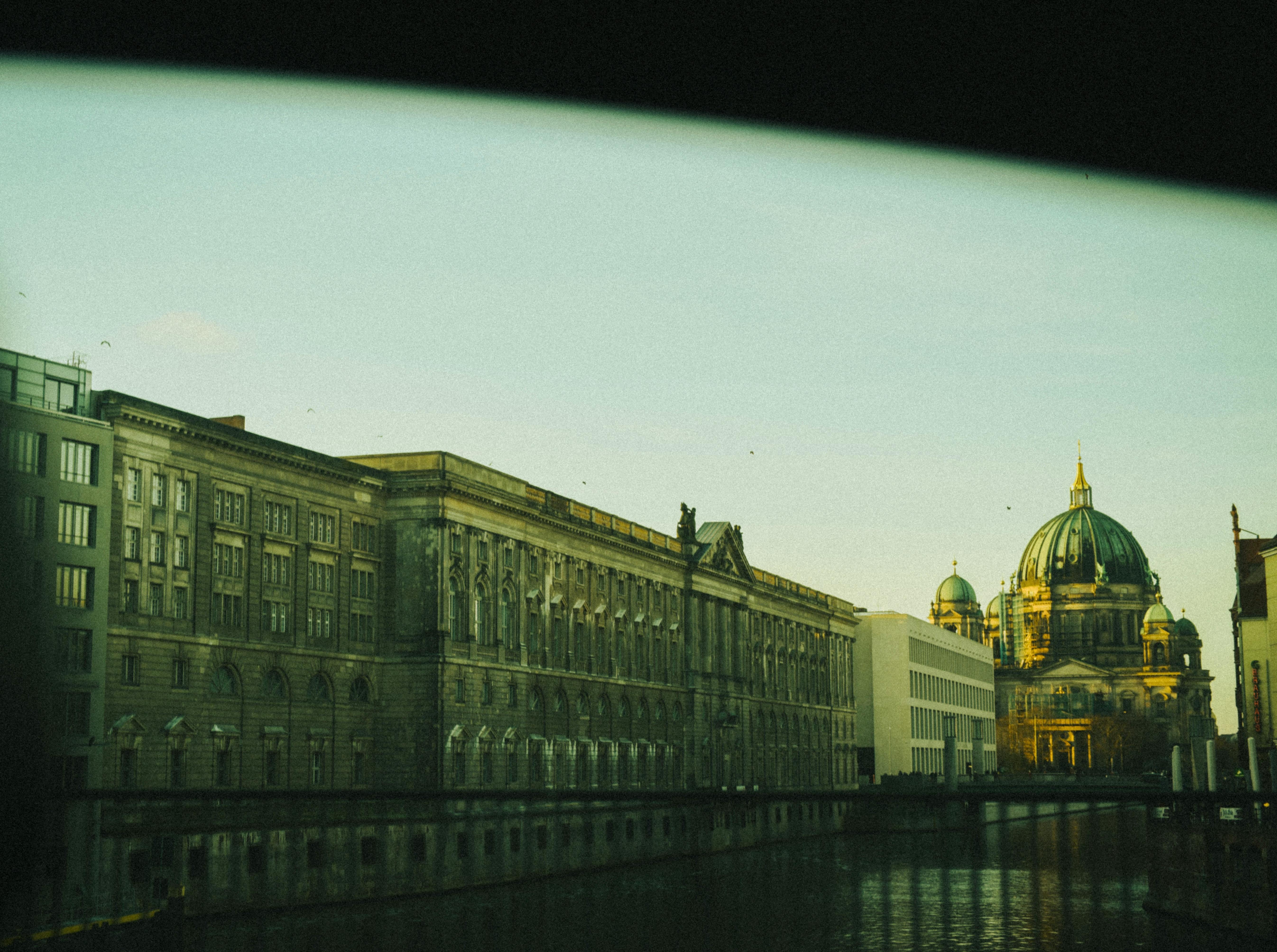 Scenic view of Berlin Cathedral with sunset reflections on water.