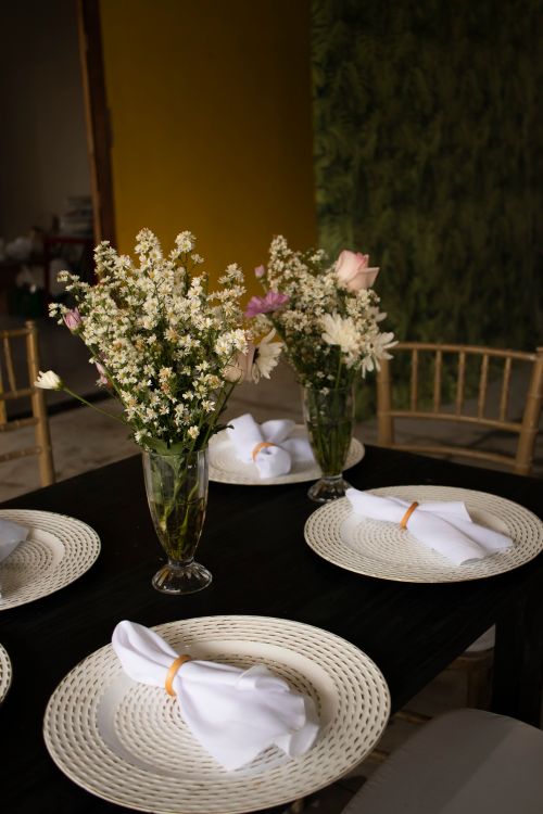 Free Close-up of a table setting with floral centerpieces and neatly folded napkins. Stock Photo