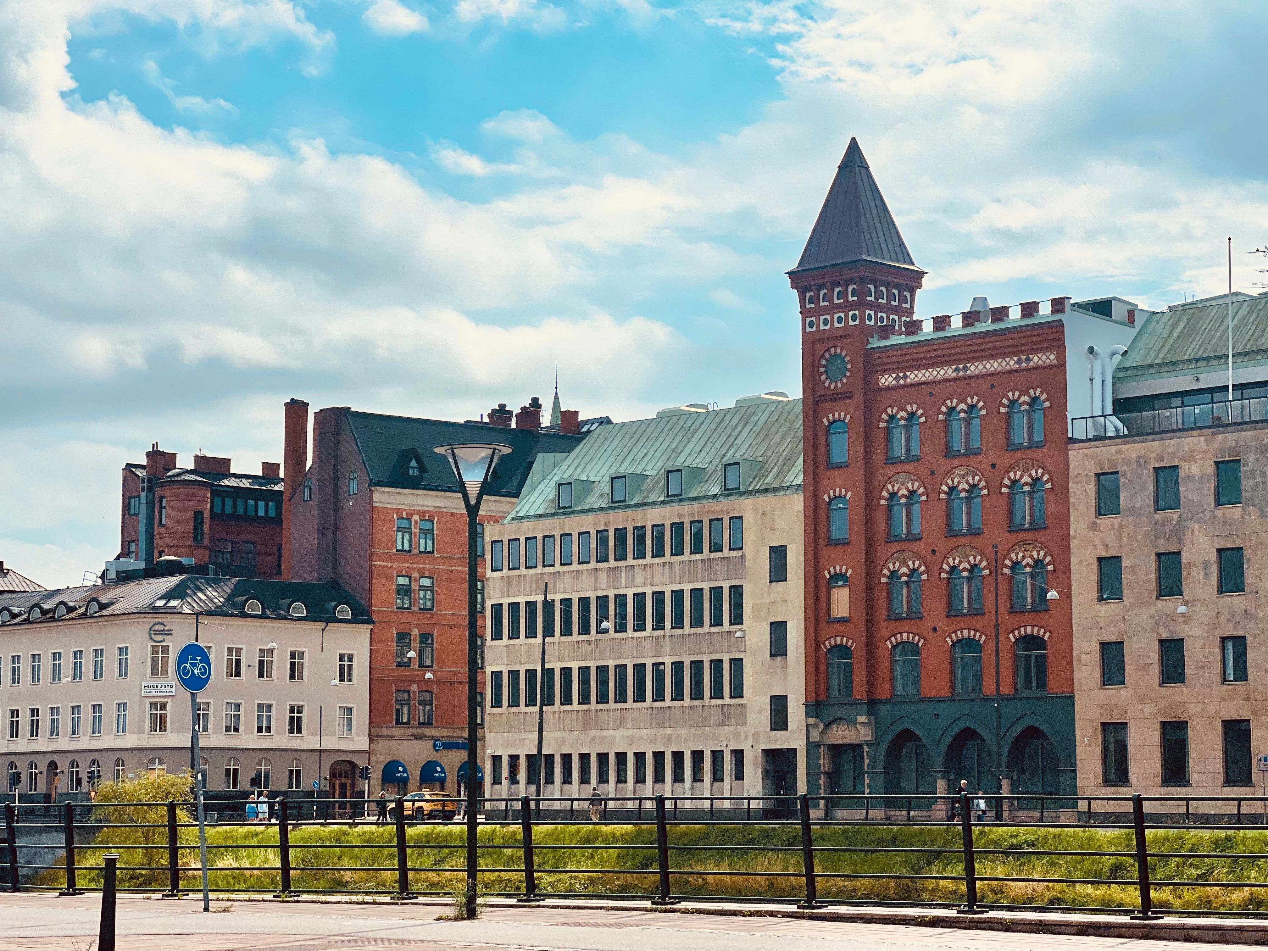 Picturesque view of historic European buildings by a canal under a bright sky.