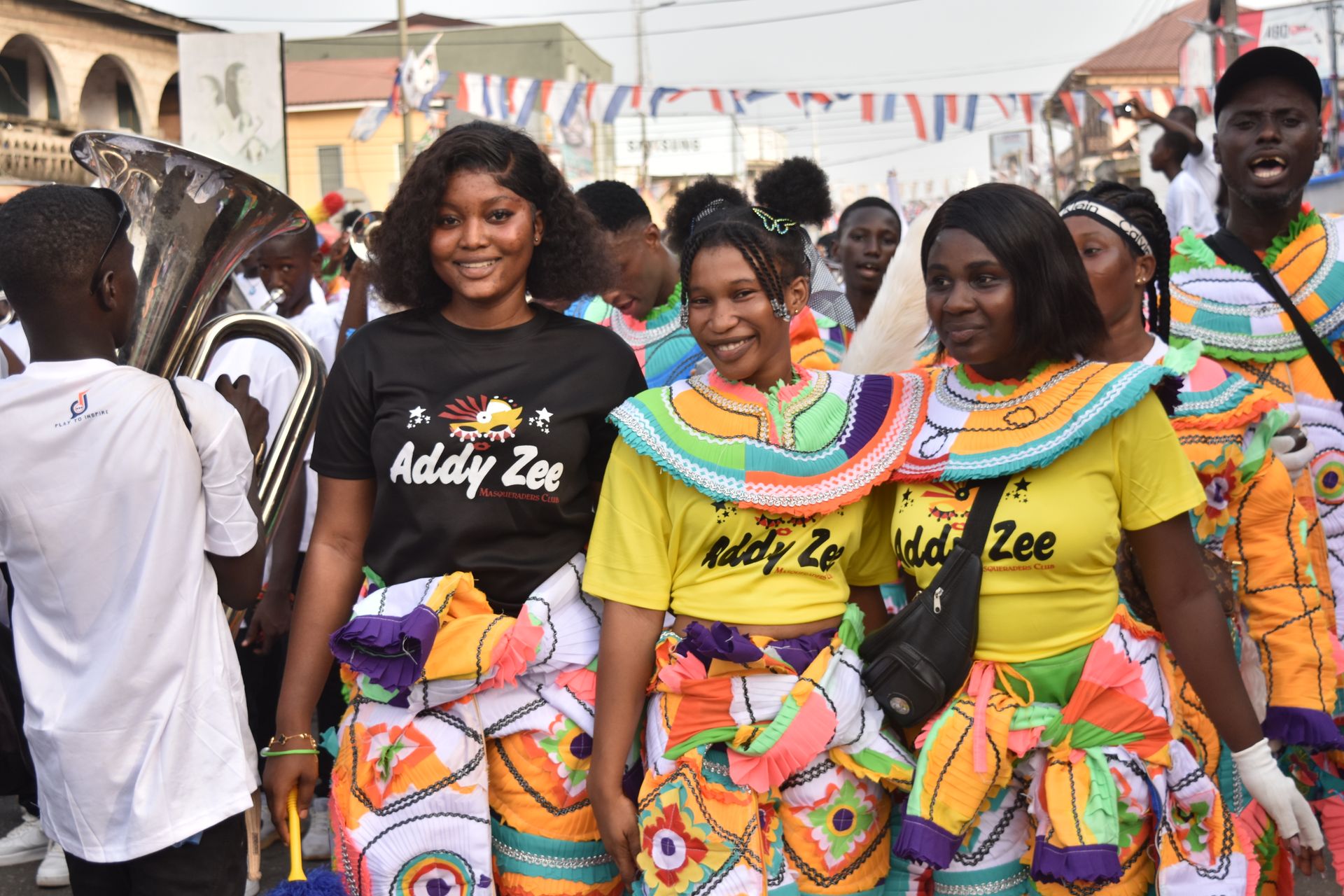 Vibrant street festival with smiling participants in colorful attire and traditional music.