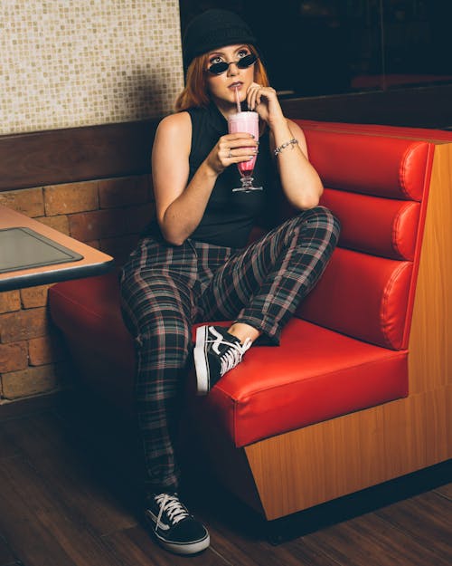 Woman Sitting on Chair Beside Table Drinking Shake