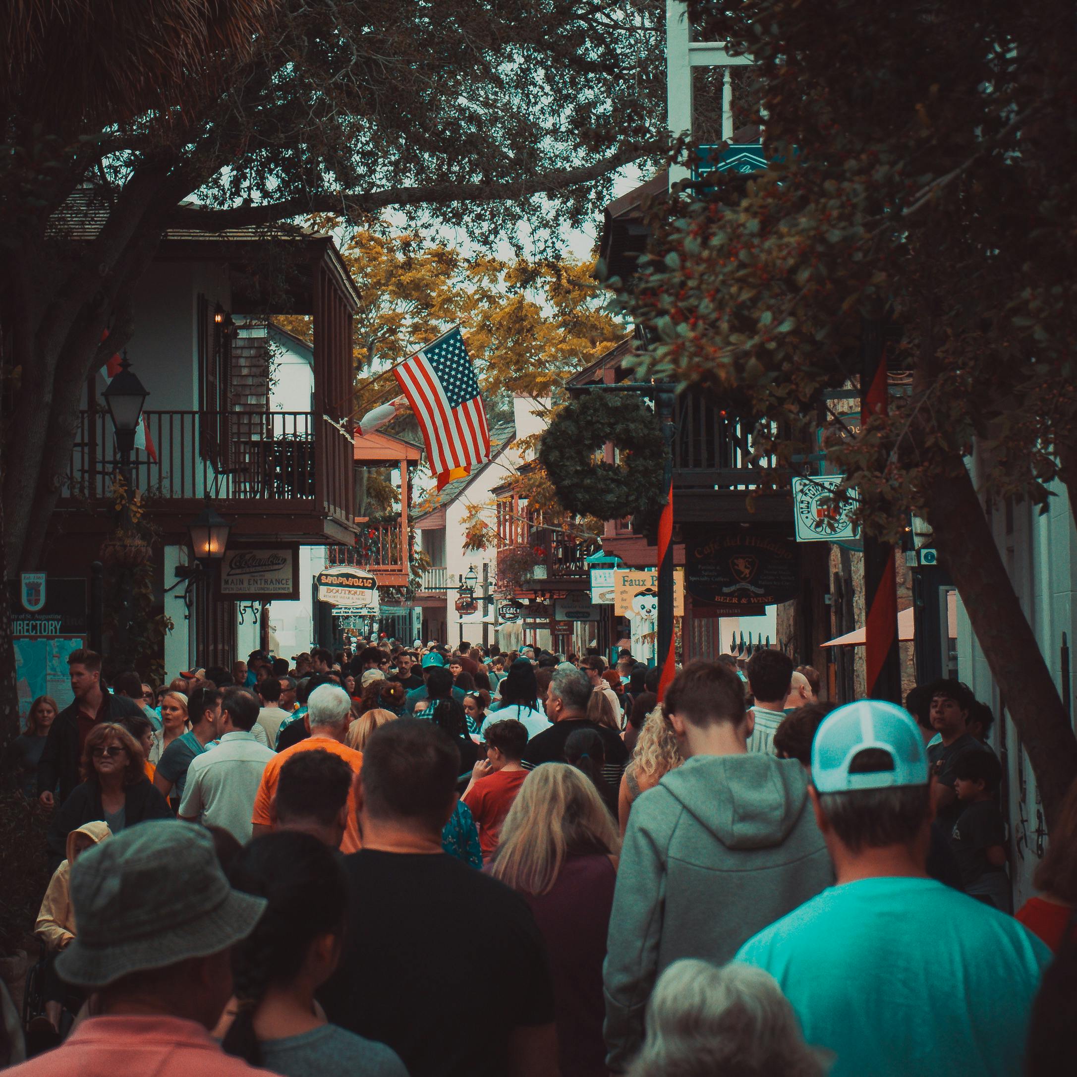 A vibrant street scene in a small town, showcasing local shops, restaurants, and community events