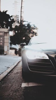 黄昏时分，一辆时尚的现代汽车亮着前灯，停在城市街道上